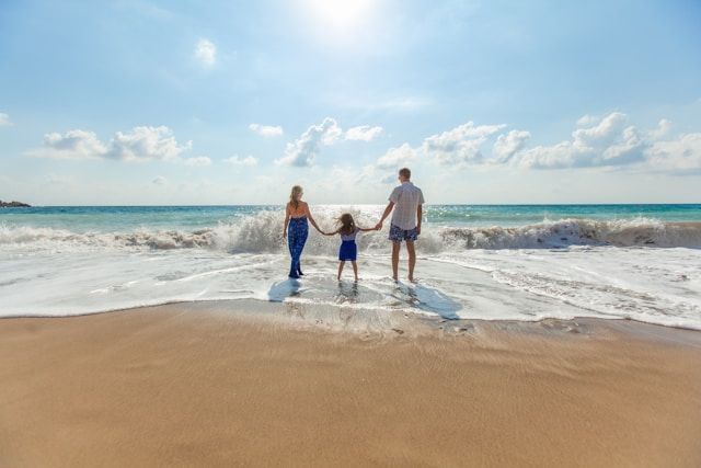 Padre y madre disfrutando de un día en la playa con su hijo, creando recuerdos familiares